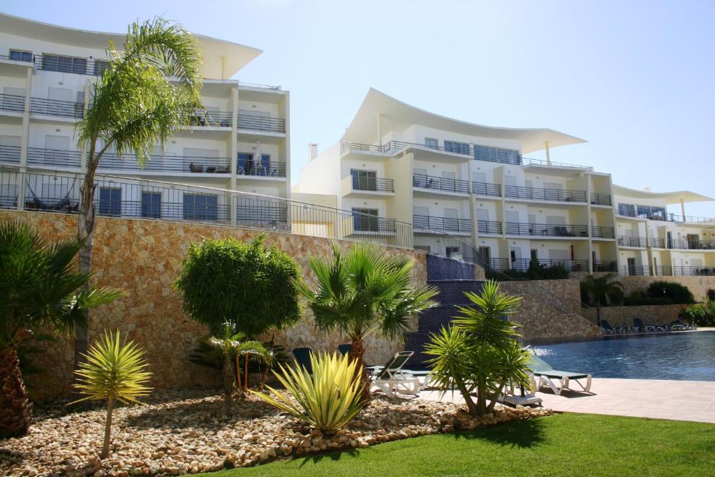 un complejo con piscina y palmeras en Condominio Encosta Da Orada by Garvetur, en Albufeira