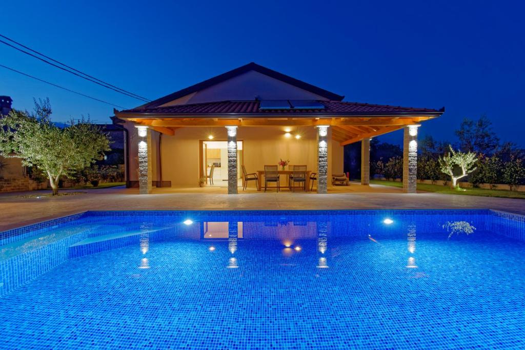- une piscine en face d'une maison la nuit dans l'établissement Villa Sonce, à Buzet