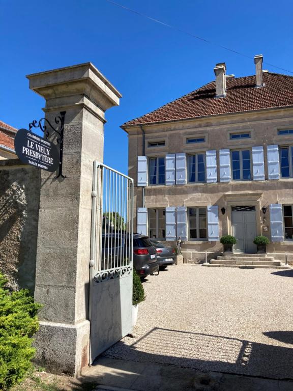 ein Tor zu einem Gebäude mit einem Schild darauf in der Unterkunft Le vieux presbytère in Confracourt