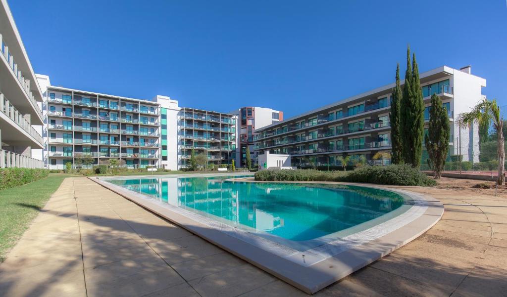 a swimming pool in front of a building at Residence Golf Club by Garvetur in Vilamoura