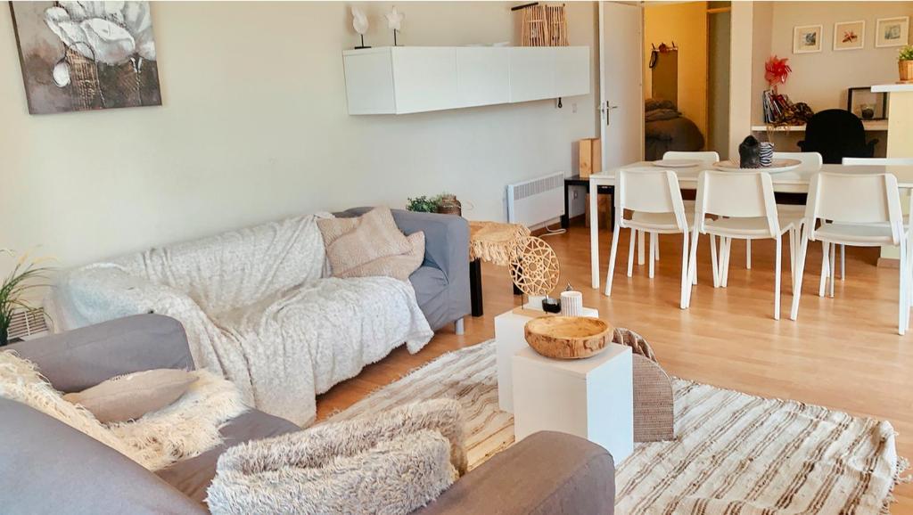 a living room with a couch and a table at Ruim, lichtrijk appartement met groot terras uitstekend gelegen in De Panne in De Panne