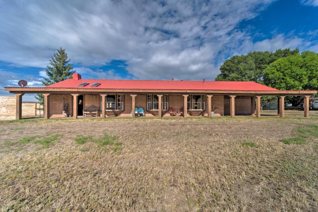 une maison avec un toit rouge sur un champ dans l'établissement Rustic Ranch Retreat with Yard 16 Mi to Ski Apache!, à Ruidoso