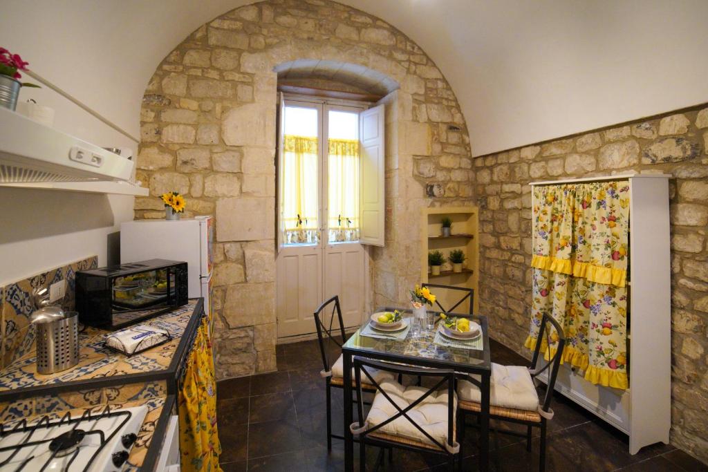 una cucina con tavolo e sedie in una stanza di Modica View a Modica