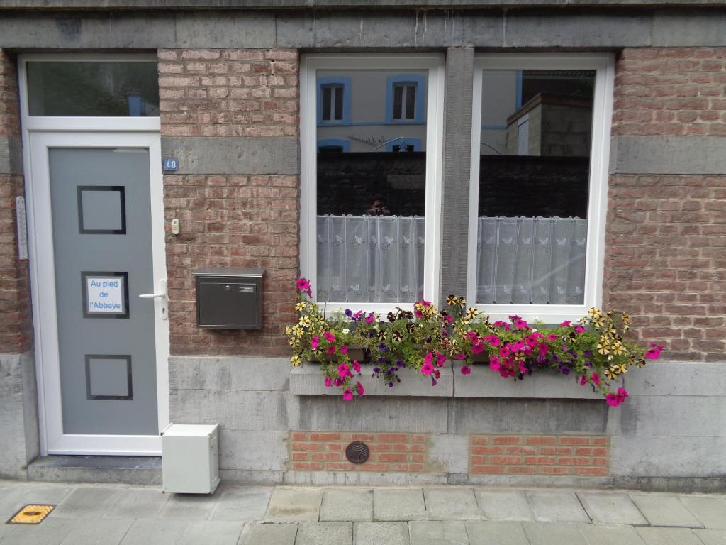 um edifício com uma janela com flores numa caixa de janela em AU PIED DE L'ABBAYE DE LEFFE em Dinant