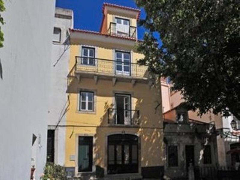リスボンにあるセ デ リスボア Iの黄色の建物(バルコニー付)