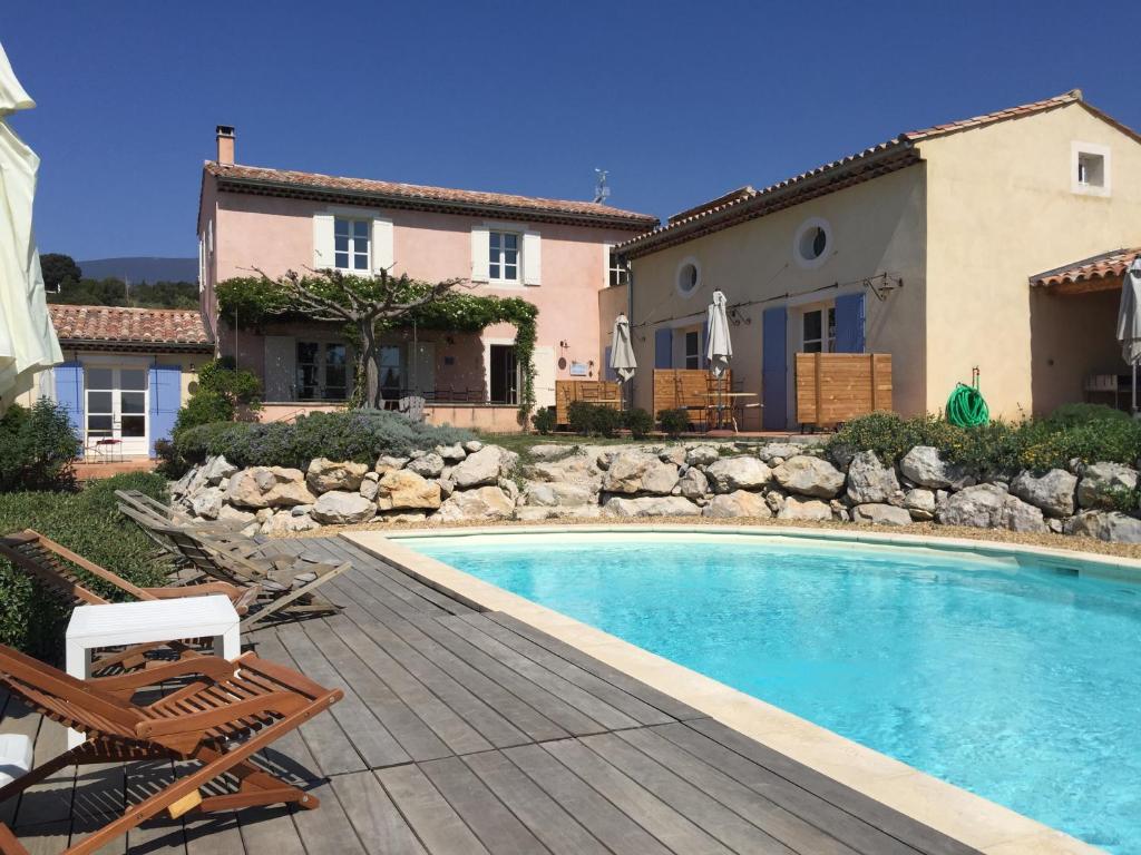 a villa with a swimming pool and a house at AU PIED DU VENTOUX in Flassan