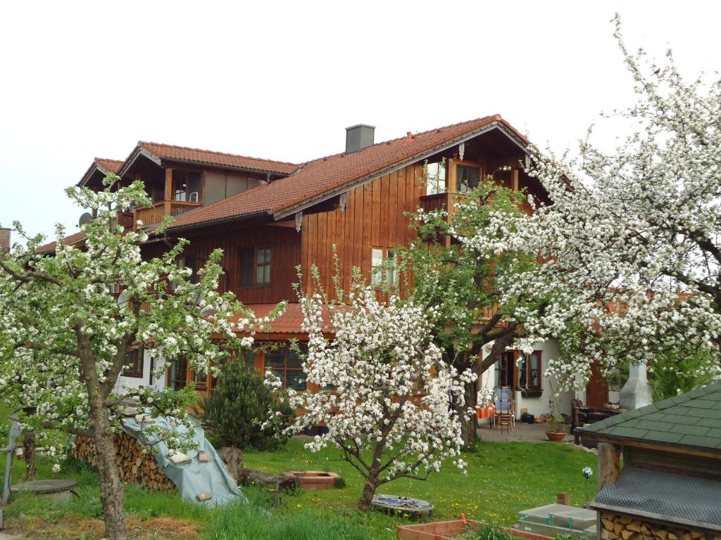 a house with flowering trees in front of it at Ferienwohnung Wingen in Bad Feilnbach