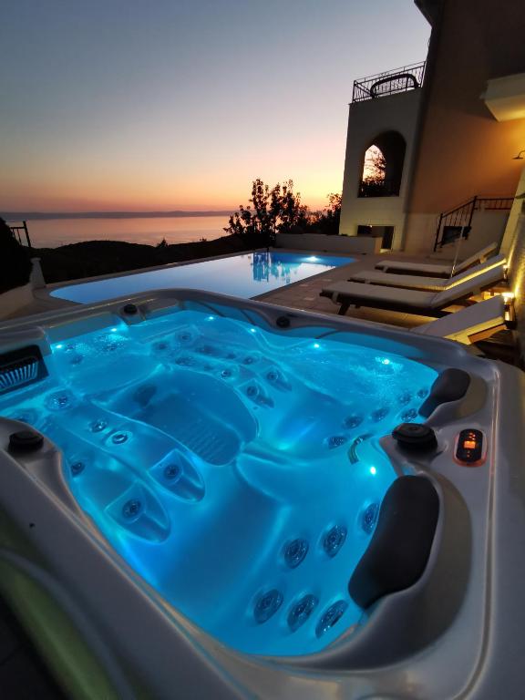 a jacuzzi tub with a sunset in the background at Villa Berina in Makarska
