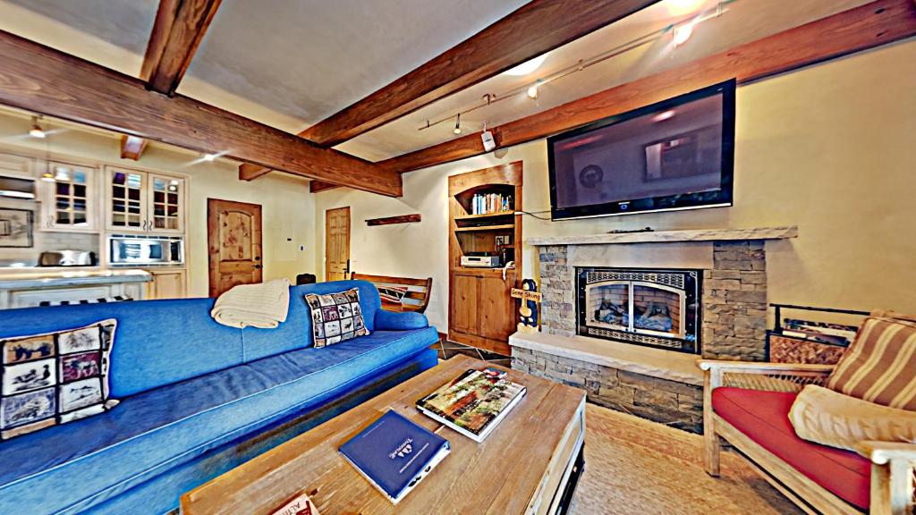 a living room with a blue couch and a fireplace at Timberline Condominiums 2 Bedroom Premier Unit C1D in Snowmass Village