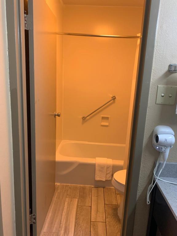 a small bathroom with a shower and a toilet at Quality Inn & Suites Brooksville I-75-Dade City in Ridge Manor