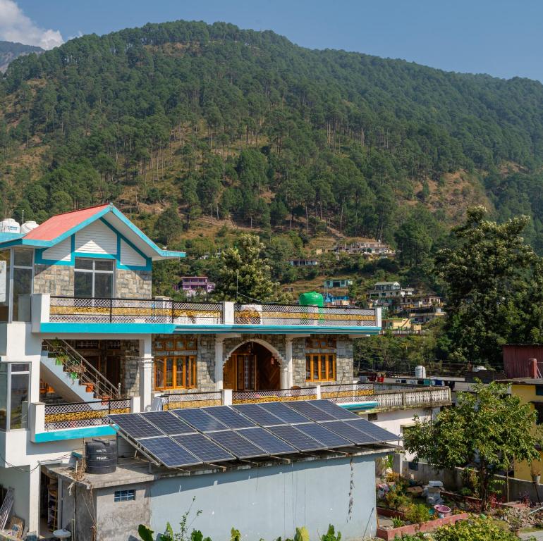 ein Gebäude mit Sonnenkollektoren darüber in der Unterkunft Hill dew homestay in Uttarkāshi