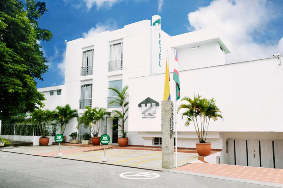 a white building with flags in front of it at Hotel Imbanaco in Cali