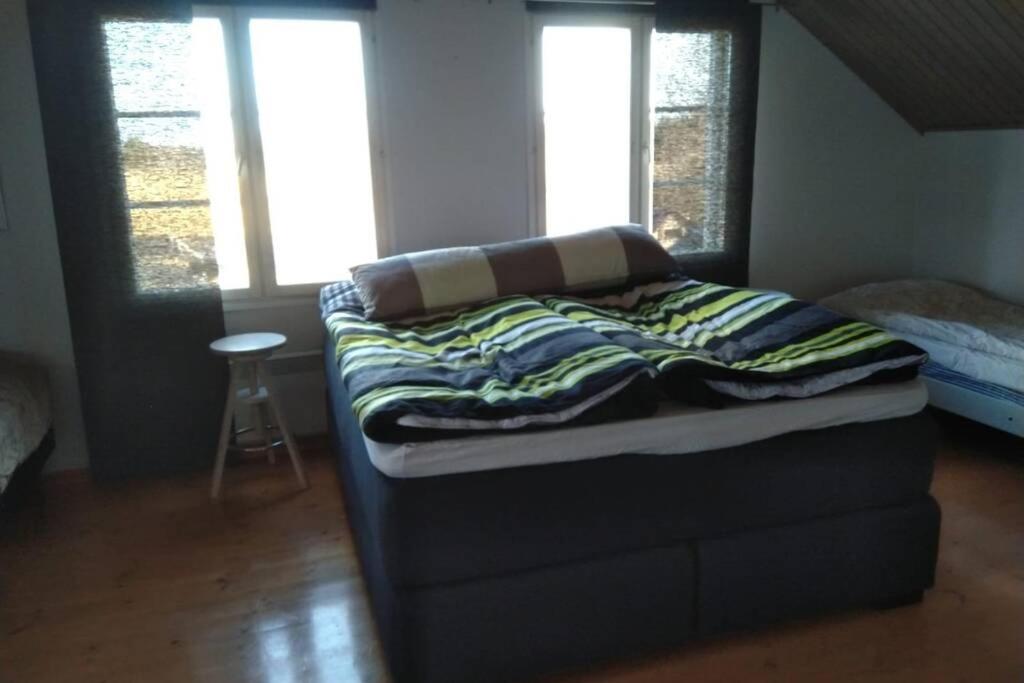 a bed with a blanket on top of it in a room at Lepola in Oulu