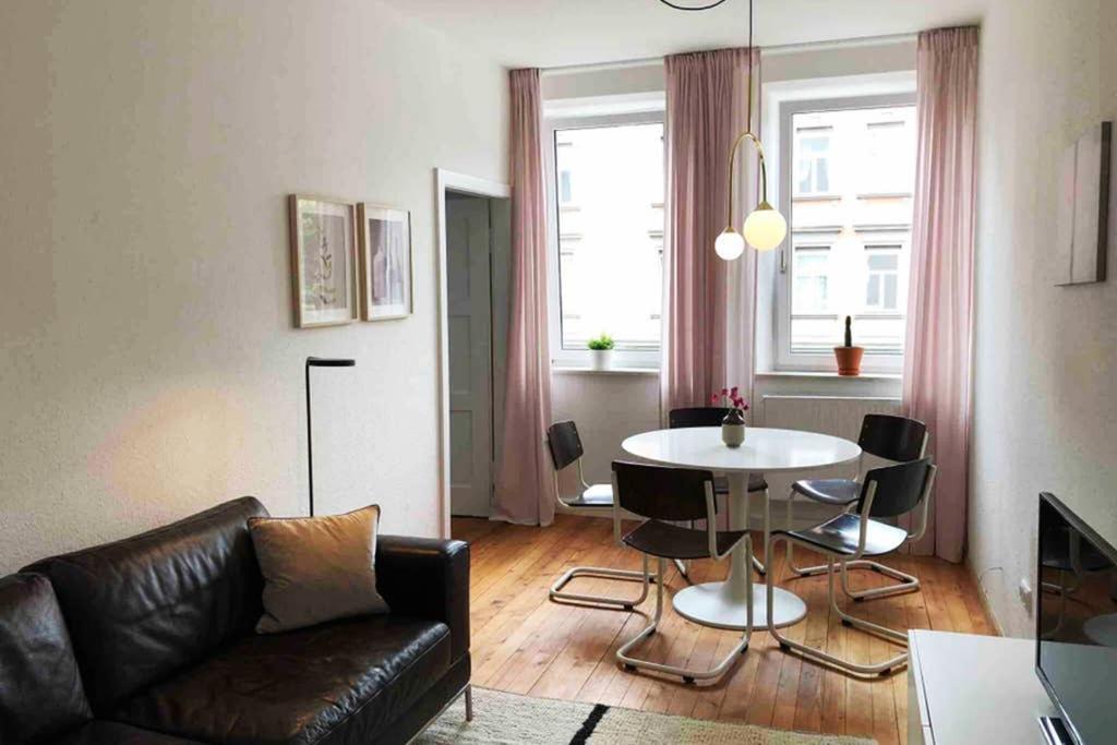 Charmant Leben im Textilviertel - stilvolle Wohnung - zentral und ruhig في اوغسبورغ: غرفة معيشة مع أريكة وطاولة