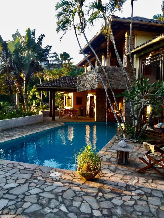 a swimming pool in front of a house at Anfiteatro Tropical in Búzios