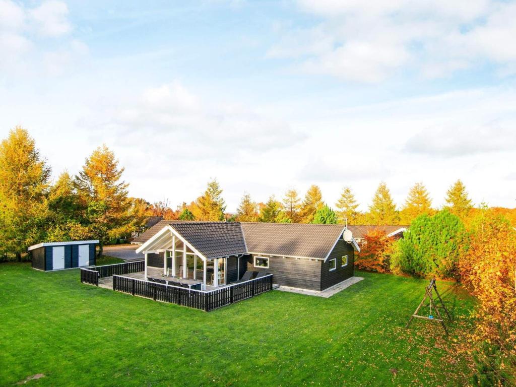 una casa con techo negro en un césped verde en 10 person holiday home in Glesborg, en Fjellerup