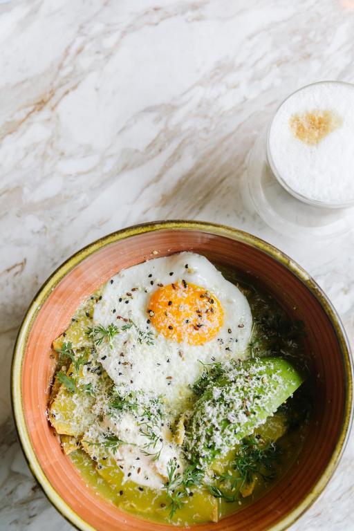 a bowl of food with eggs and broccoli on a table at Brick Hotel Mexico City - Small Luxury Hotels of the World in Mexico City