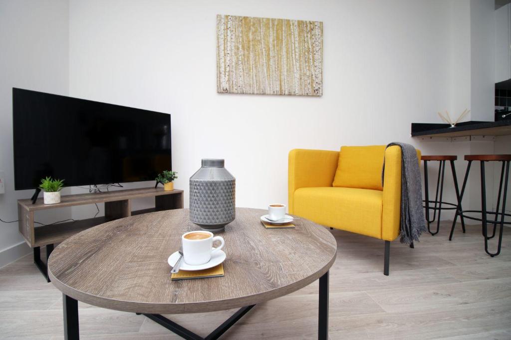 uma sala de estar com uma mesa de centro e uma cadeira amarela em No1 Marina Walk by Stay South Wales -FREE Parking em Swansea