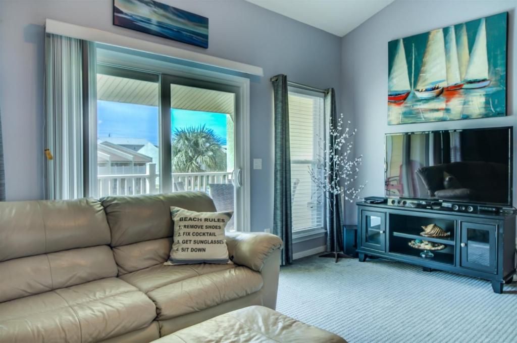 a living room with a couch and a tv at Seacove 7E 2 Bedroom Condo in Destin