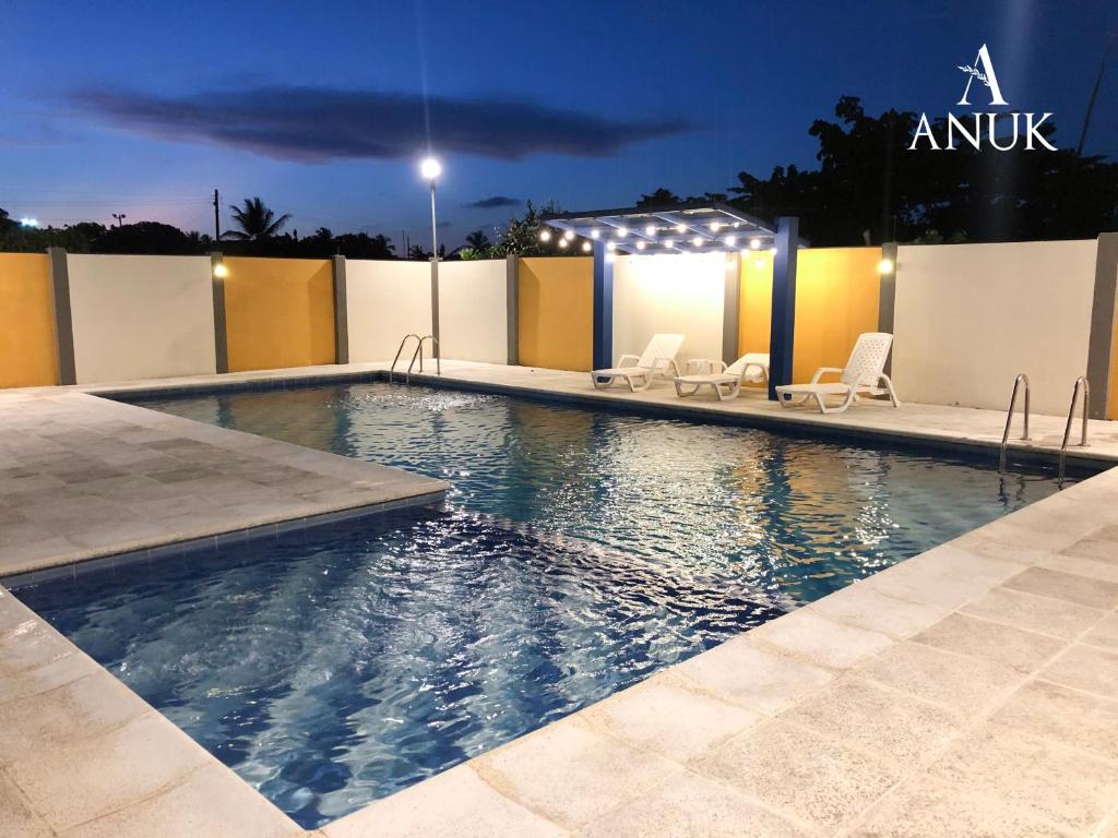 - une piscine avec des chaises et des lumières la nuit dans l'établissement Anuk Glamping, à San Bernardo del Viento