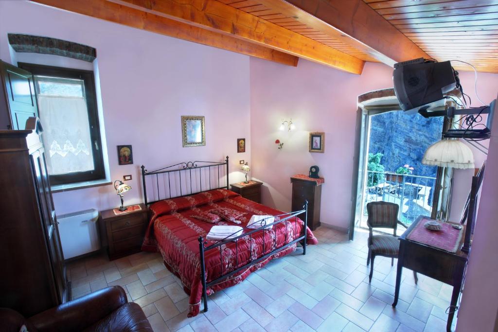 a bedroom with a red bed and a television in it at Il Belvedere in Civita