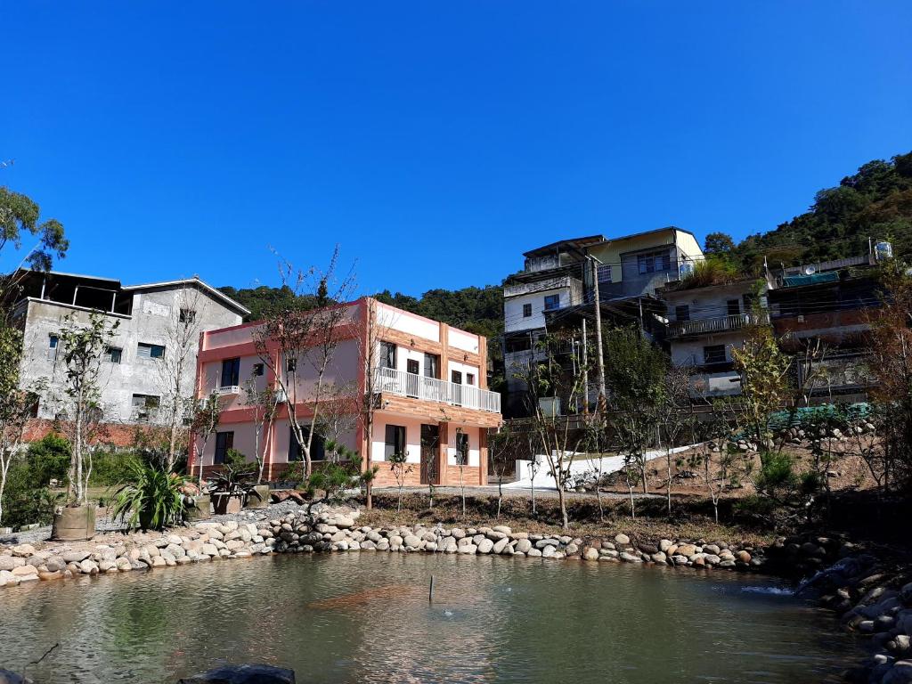 um grupo de edifícios junto a um rio em 無盡夏民宿 em Nanzhuang