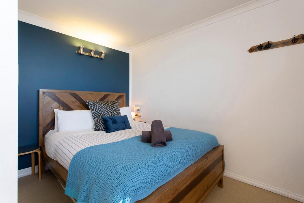 
a bedroom with a blue bed and a white comforter at Fremantle Heaven in Fremantle
