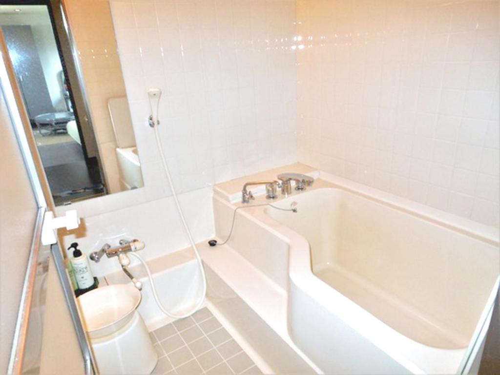un bagno con vasca, WC e lavandino di J-Garden a Ito
