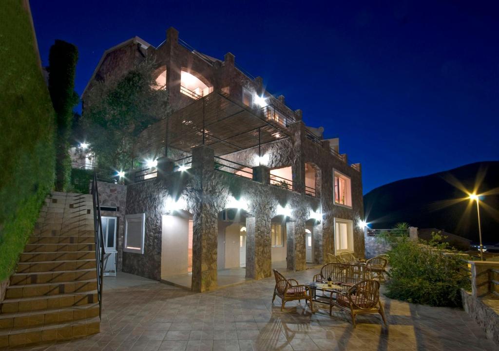 a house with a table and chairs at night at Contessa Apartments in Budva