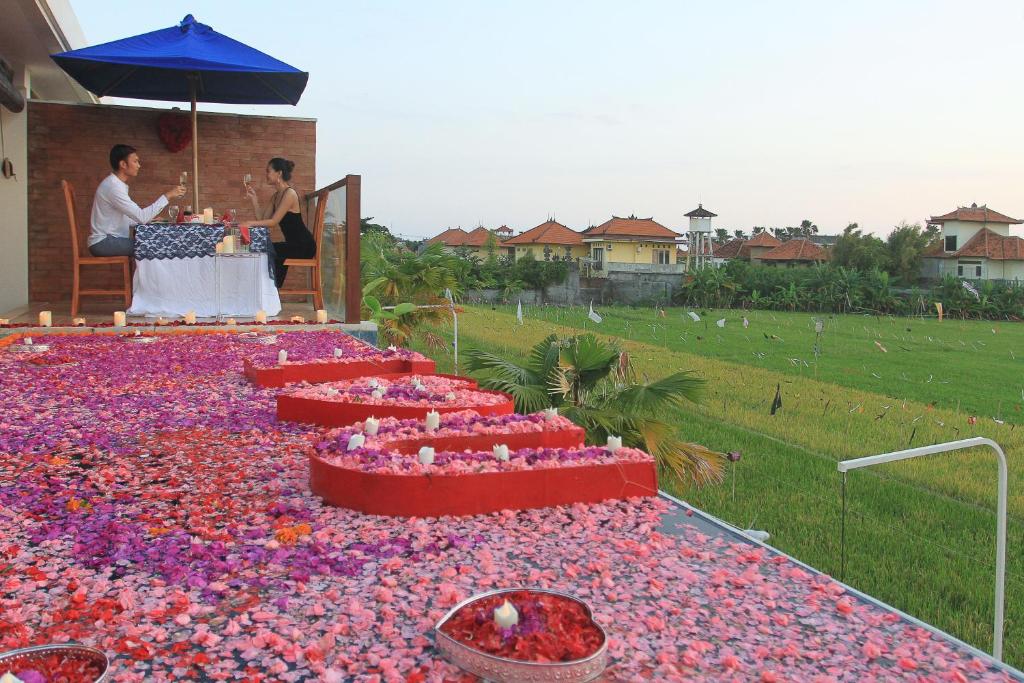 a group of people sitting at a table covered in flowers at The Wina Villa Seminyak in Seminyak