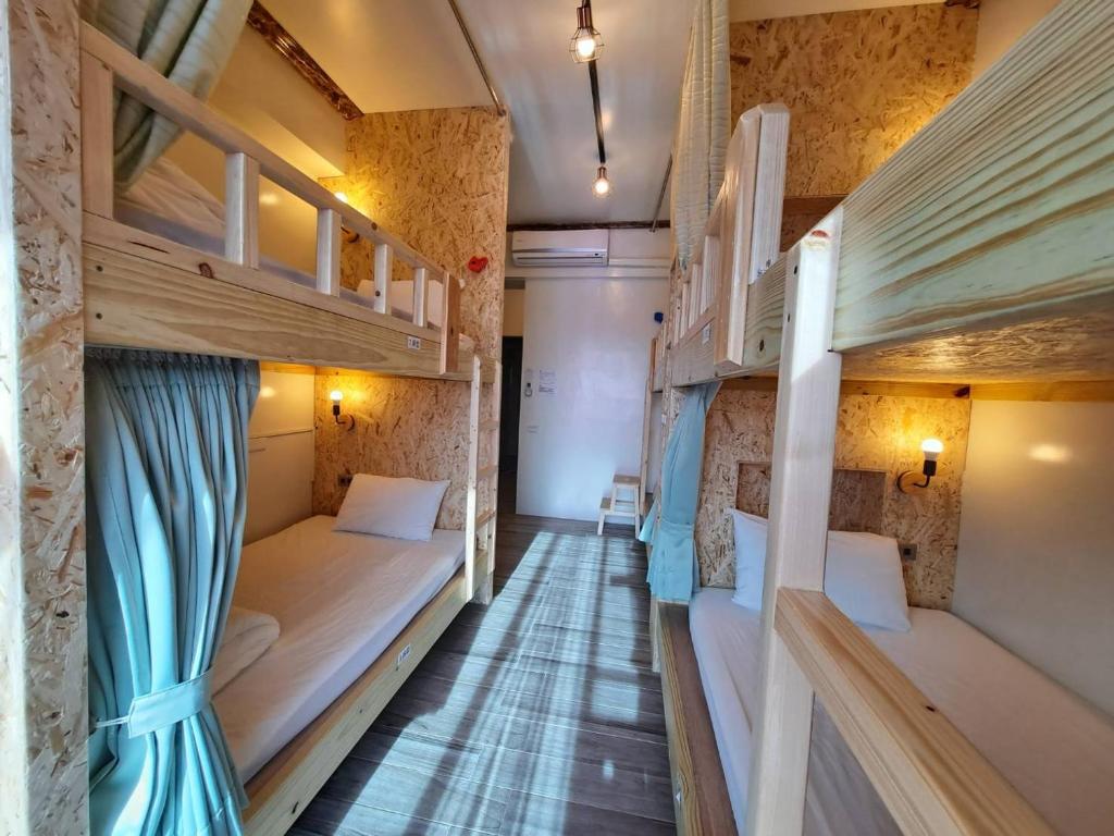 a corridor of a room with bunk beds at 墾丁秋莊會館 附限量停車位 不保證有位置 無法事先預留 背包房無車位 預訂後記得加Line聯繫 in Hengchun