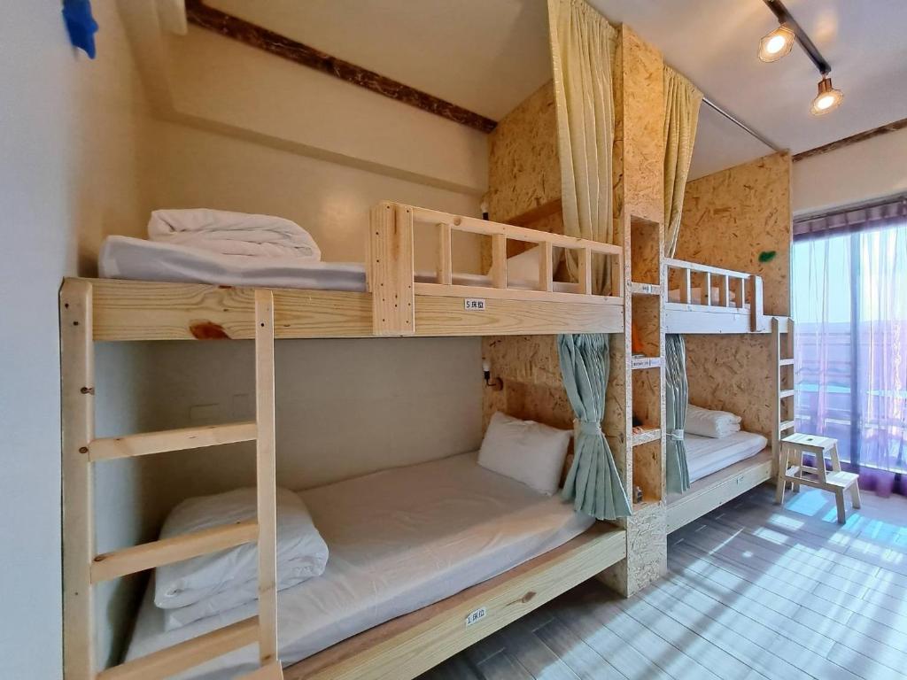a bedroom with bunk beds in a room at 墾丁秋莊會館 附限量停車位 不保證有位置 無法事先預留 背包房無車位 預訂後記得加Line聯繫 in Hengchun