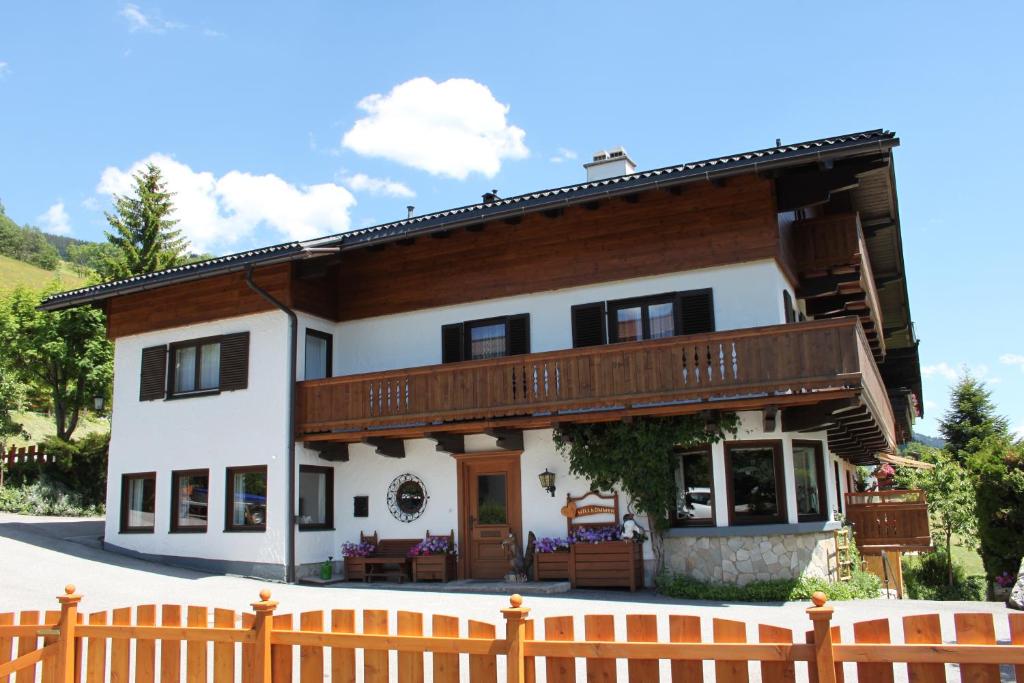 dom z drewnianym płotem przed nim w obiekcie Pension Aberger w Saalbach Hinterglemm