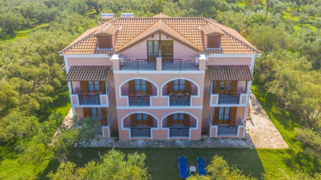 an aerial view of a large pink house at Kavos Psarou Studios & Apartments in Alykes