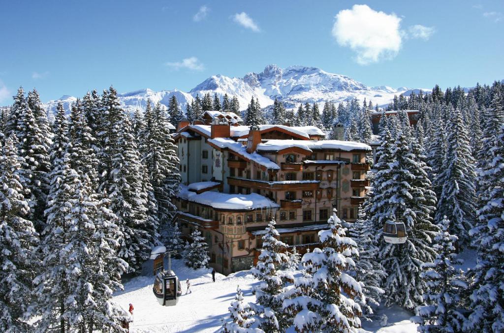 um alojamento de esqui com árvores cobertas de neve e um teleférico em Airelles Courchevel, Les Airelles em Courchevel