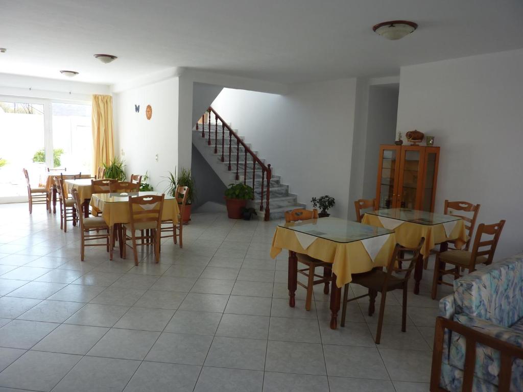 a restaurant with tables and chairs and a staircase at Arsinoi Studios and Apartments in Kalamaki