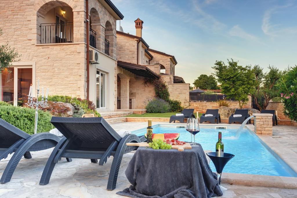 a patio with a table and chairs next to a pool at Villa Branka in Rovinjsko Selo