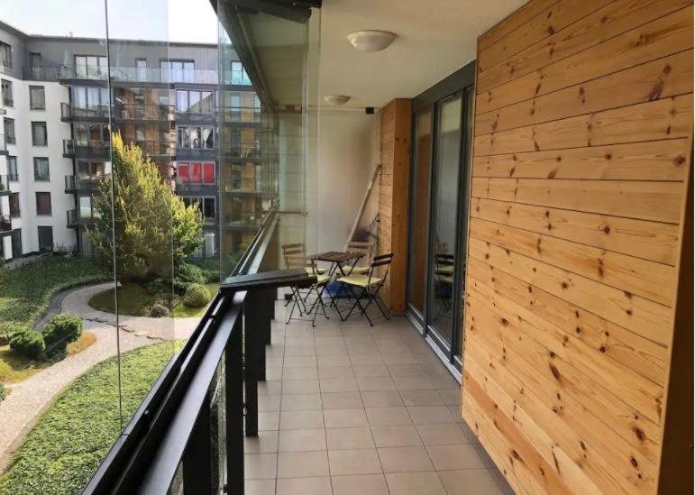 einen Balkon mit einem Tisch und Stühlen in einem Gebäude in der Unterkunft Apartment on the Boulvard in Krakau