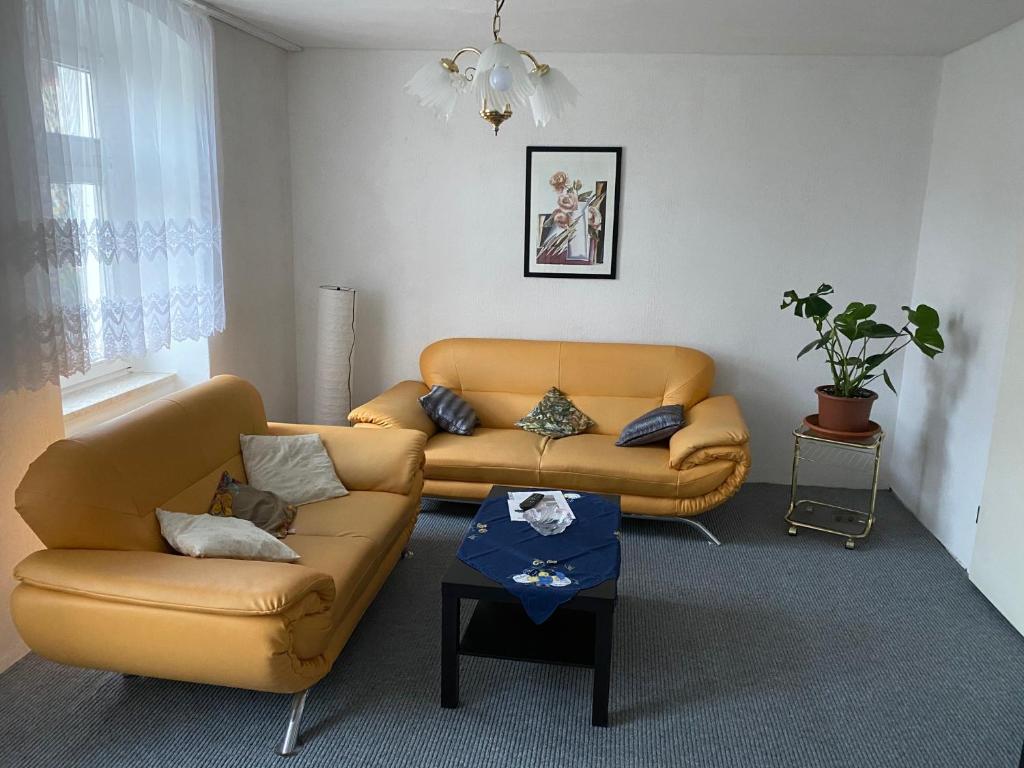 een woonkamer met een bank en een tafel bij Ferienwohnung Etgersleben in Etgersleben