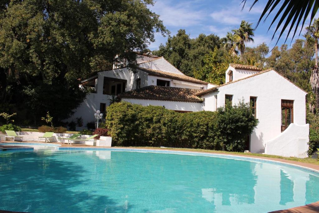 a swimming pool in front of a white house at Casa Bourani in Casares