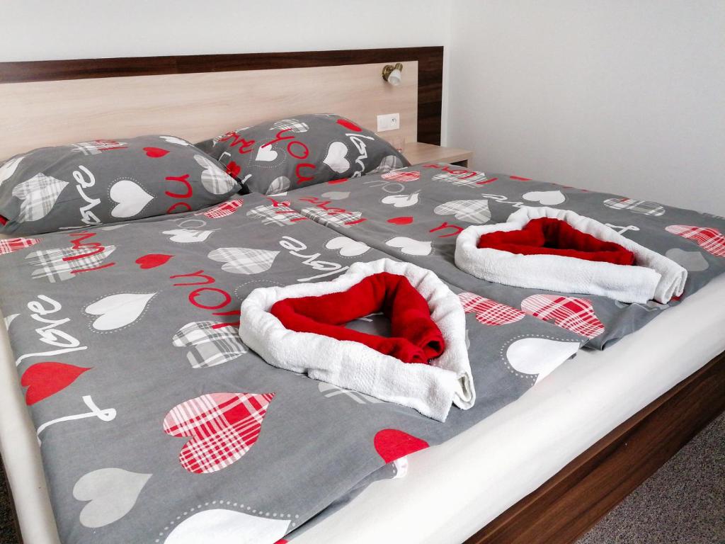 1 cama con almohadas y mantas rojas y blancas en Hostel Vodna 1 en Košice