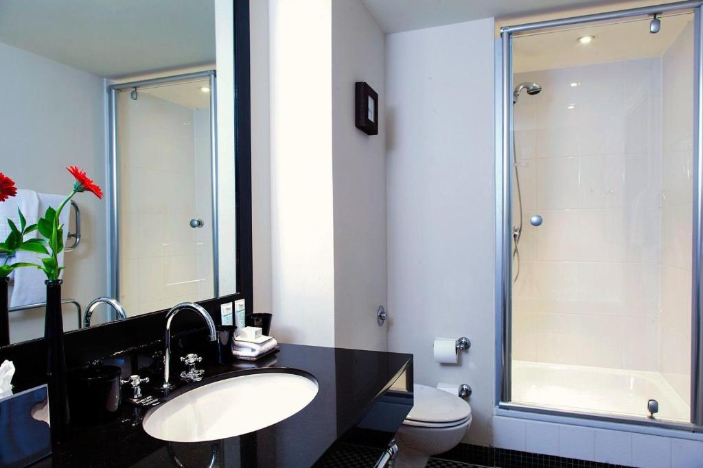 a bathroom with a shower, sink, and toilet at Malmaison Edinburgh in Edinburgh