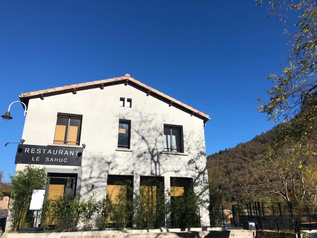 um velho edifício branco com um cartaz em Le Sahuc em Rivière-sur-Tarn