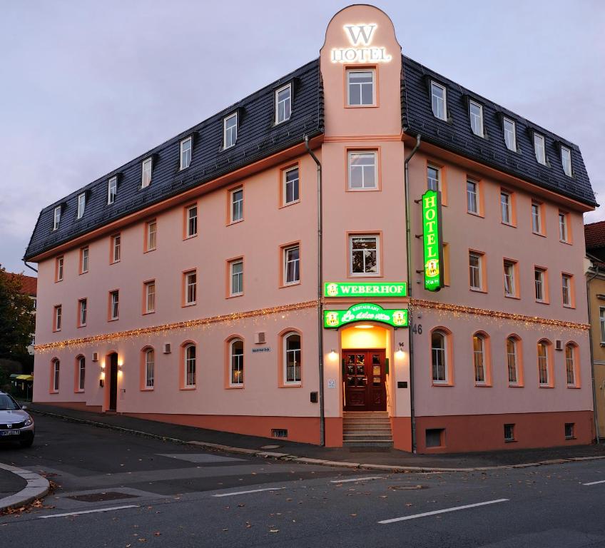 a large building with a sign on the side of it at Hotel Weberhof in Zittau