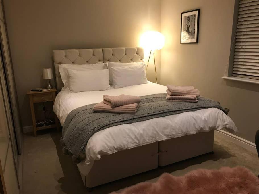 a bedroom with a bed with two towels on it at Northdown Lodge - Stunning property on the Kent Northdowns in Hollingbourne