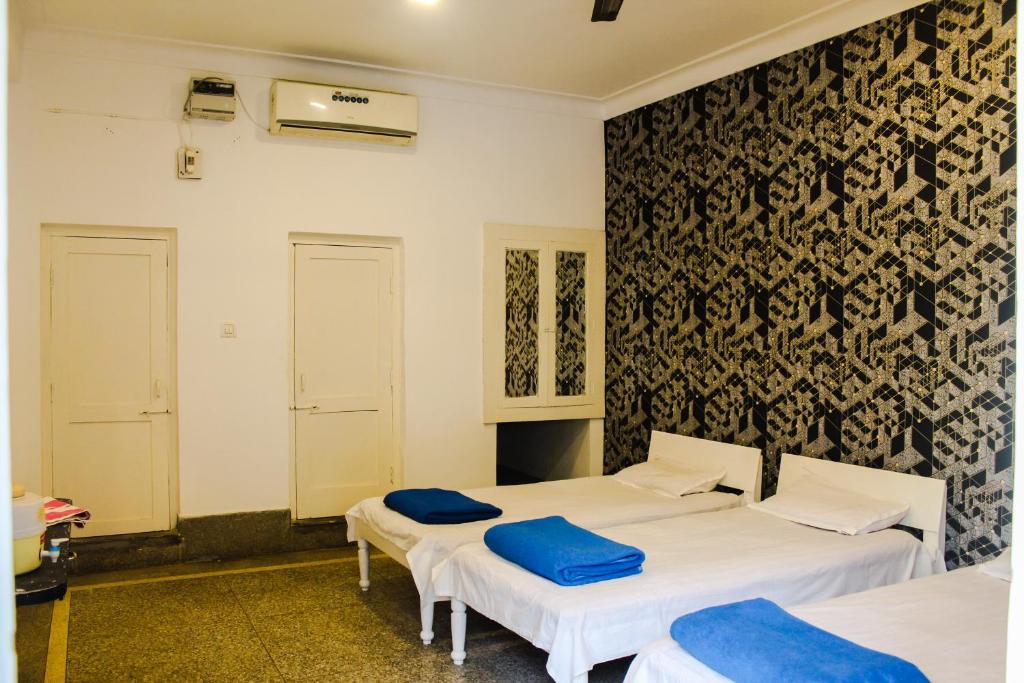 two beds in a room with a black and white wall at Hotel Anand Palace in Gwalior