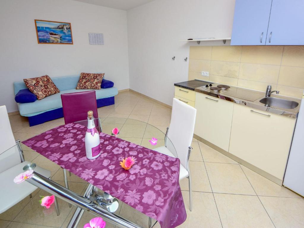 een keuken met een tafel met een fles wijn erop bij Apartment Vinka-2 by Interhome in Trogir