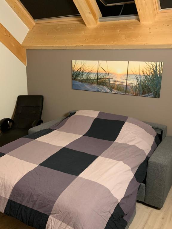 een slaapkamer met een bed en een schilderij aan de muur bij Ecolodge Zen Otra Cosa in Mouscron