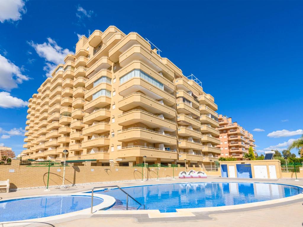 un gran edificio con una piscina frente a él en Apartment Cala Blanca II - 1ª Linea Frontal-1 by Interhome, en Oropesa del Mar