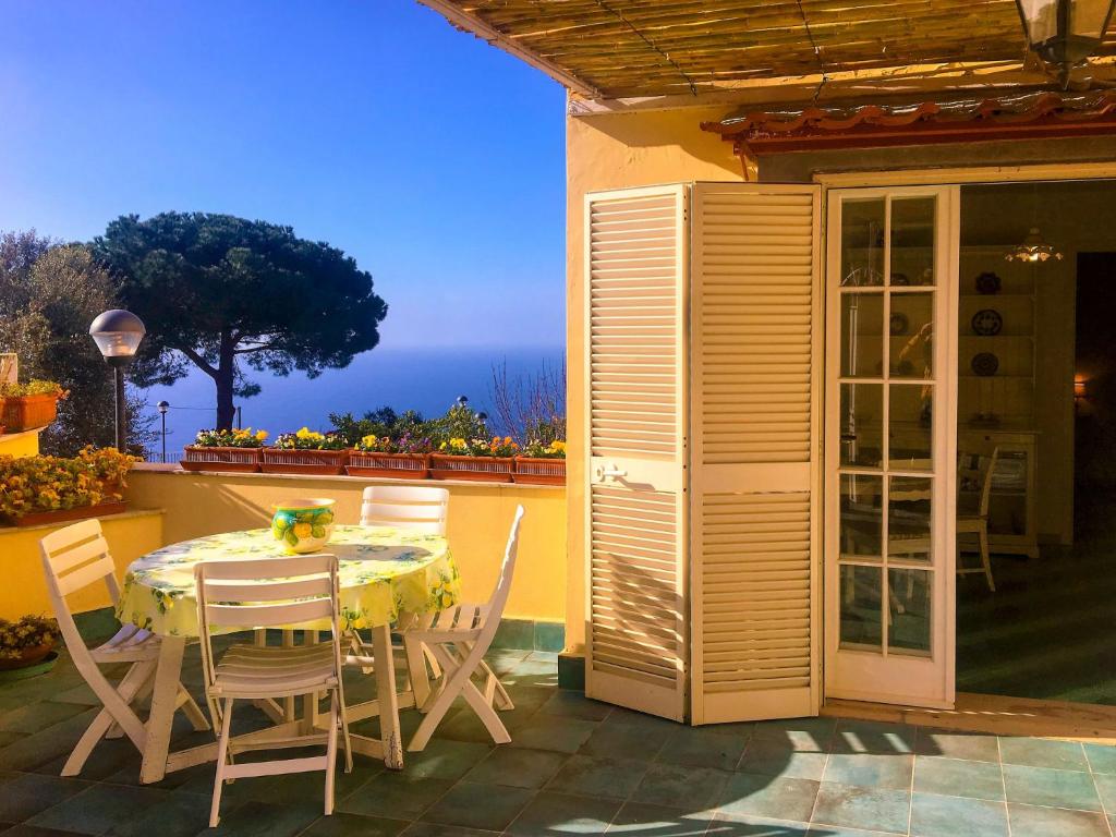 een tafel en stoelen op een patio met uitzicht op de oceaan bij Apartment Casale di Torca by Interhome in Torca